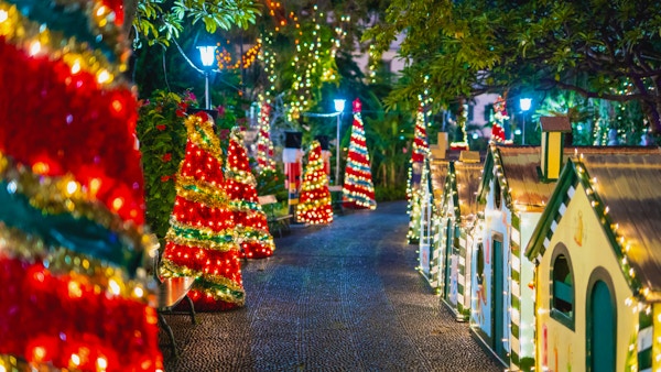 Juledekorasjoner i rødt, gull og grønt langs ei gate