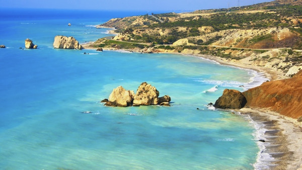 Lyseblått hav og steinete landskap ved kysten på Kypros