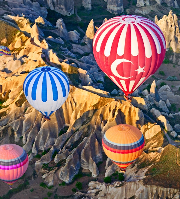Luftballonger over fjellandskapet i Cappadocia, Goreme nasjonalpark, Tyrkia.