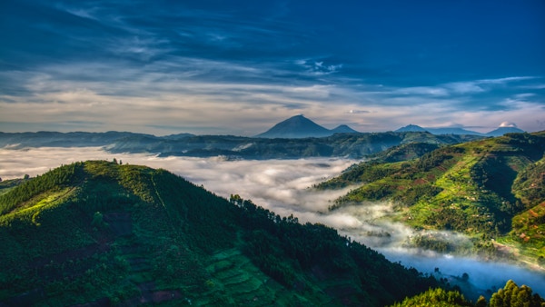 Morgentåke og tåke som strekker seg gjennom dalen i høylandet i Uganda med Mabamba-vulkanen i bakgrunnen