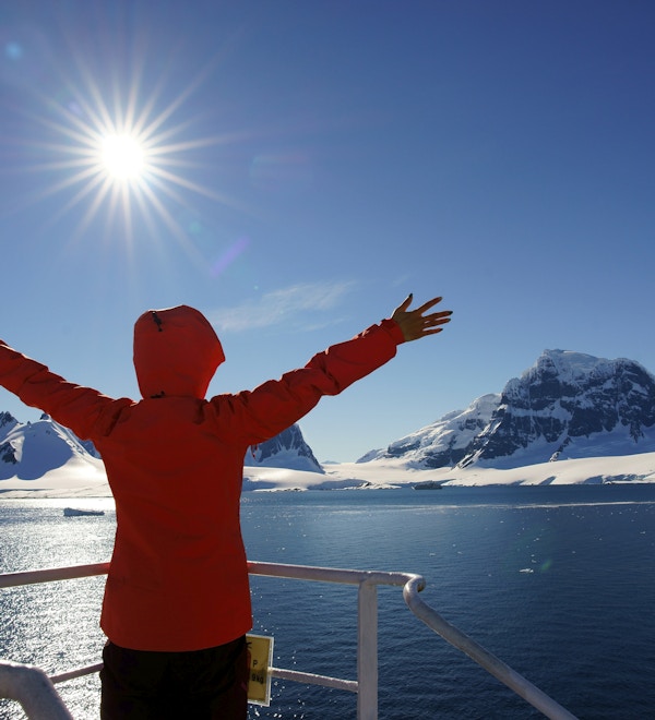 Kvinne som ser på isbreen i Antarktis fra båten