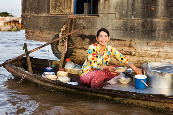 "Vietnamesisk Pho-selger på flytende marked - kvinne som selger nuddelsuppe fra båten sin i Mekong-elvedeltaet, Vietnam. Pho er en vietnamesisk nuddelsuppe, vanligvis servert med storfekjøtt eller kylling."