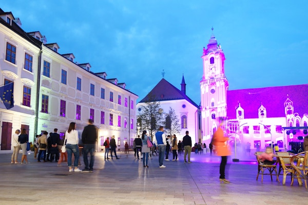 Folk ser et lilla lysshow på hovedtorget i gamlebyen i Bratislava, Slovakia