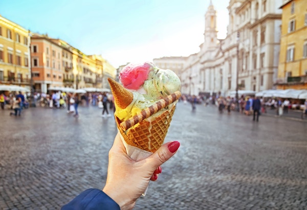 Italiensk iskrem holdt i hånden på bakgrunnen til Piazza Navona i Roma, Italia