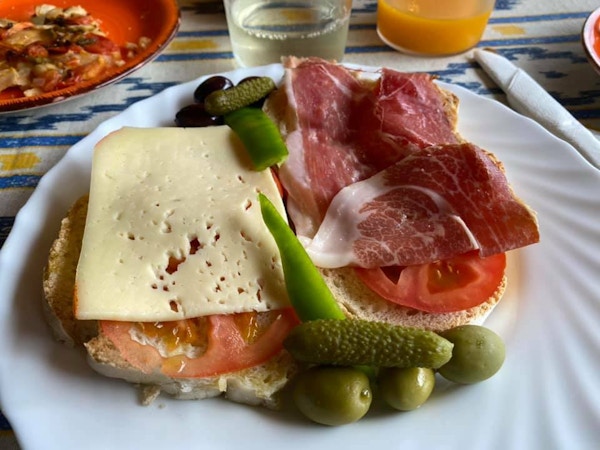 Brød med ost, tomat, oliven og skinke
