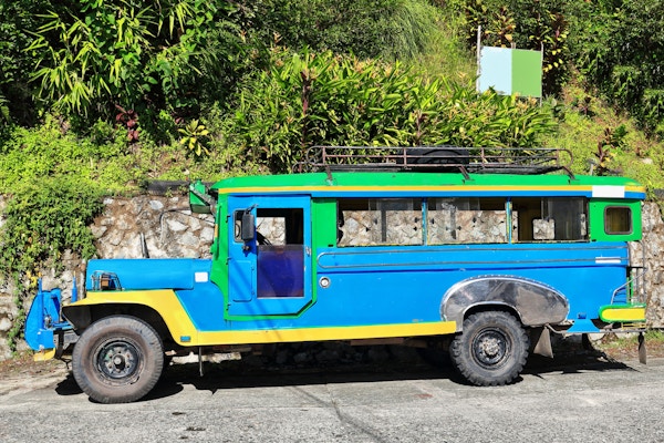 Filippinsk grønn-blå-gul dyipni-jeepney bil. Offentlig transport i Banaue by, opprinnelig laget av amerikanske militære jeeper som var igjen fra WW.II lokalt endret - nå fra japansk overskudd. Filippinene.