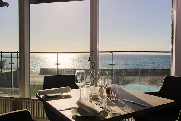 Dekket bord i restaurant, med utsikt over sjøen