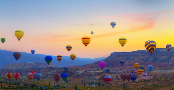 Luftballonger som lander på et fjell Cappadocia Goreme nasjonalpark i Tyrkia.