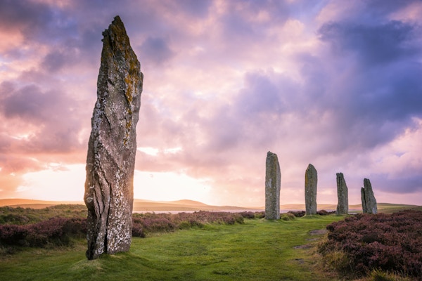 De eldgamle steinene fra Ring of Brodgar på Orknøyene utenfor nordkysten av Skottland, om kvelden like ved solnedgang.