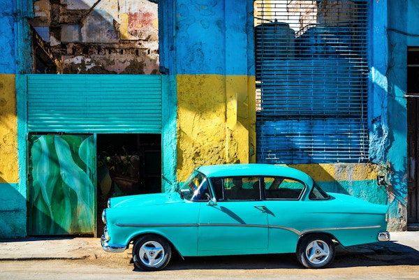 Gammel amerikansk bil som kjører i en gate i gamle Havanna, Cuba