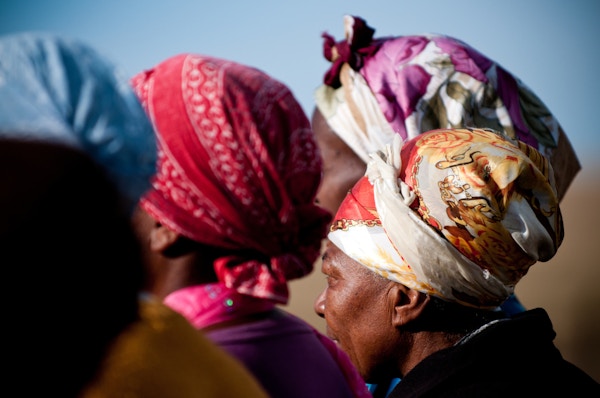 Afrikanske kvinner ikledd fargerike hodeskjerf. Foto tatt fra baksiden. Transkei, Sør-Afrika.