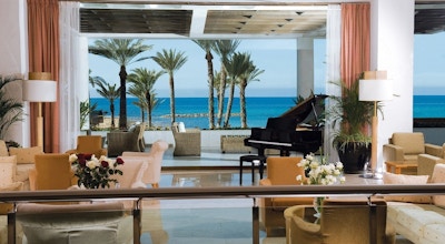 Hyggelig møblert lobby med piano og utsikt over sjøen