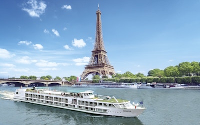Elvecruiseskip seiler på Seinen forbi Eiffeltårnet.