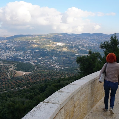 En kvinne som står ved panoramautsikt og ser ut mot byen Ajloun