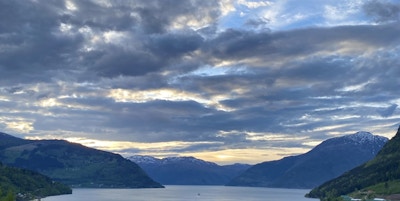 Solnedgang over Kinsarvik med Hardangerfjorden og fjellene i bakgrunnen