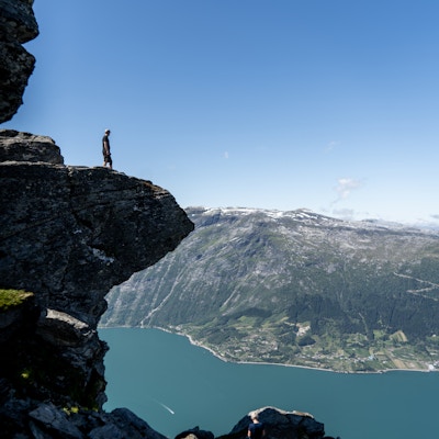 En mann står på en klippe på Dronningstien og ser utover Hardangerfjorden