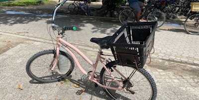 Rosa sykkel parkert ved en strand