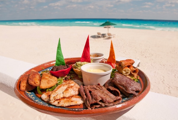 En tallerken autentisk meksikansk mat serveres på en strand på stranden.