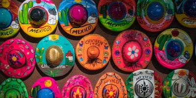 Nærbilde av kreative fargerike leketøymagneter med hatter farget vakkert i meksikansk stil.