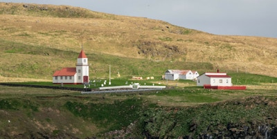 En liten bosetting og kirke med rødt tak