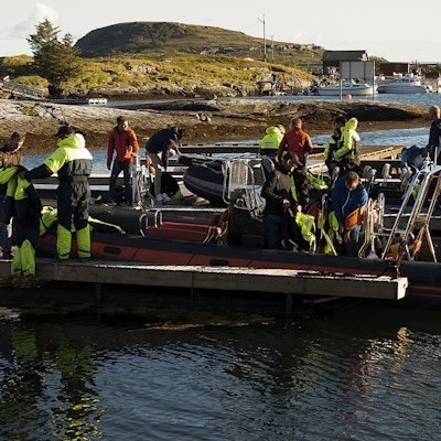 Flere personer i verneutstyr gjør seg klare til å sette av gårde i en RIB-båt på vannet