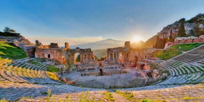 Det gamle Taormina-teateret med utbrudd fra vulkanen Etna ved solnedgang