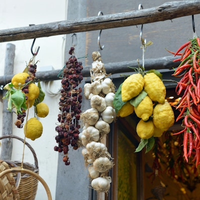 Sitroner, hvitløk og Chili som henger utenfor en butikk på Amalfikysten i Italia