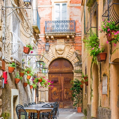 Kafébord og stoler ute i den gamle koselige gaten i Positano-byen, Campania, Italia