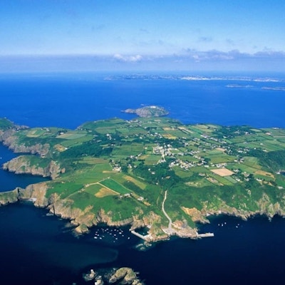 Oversiktsbilde over ei øy i Den engelske kanal med spredt bebyggelse og mest grønne områder