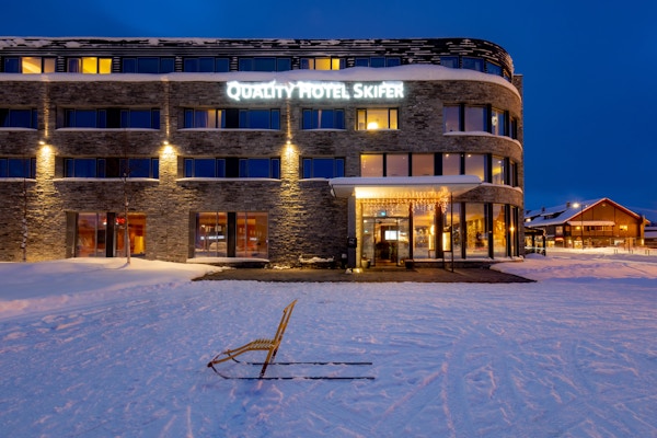 En ensom sparkstøtting står utenfor hotellinngangen og vinterlandskap