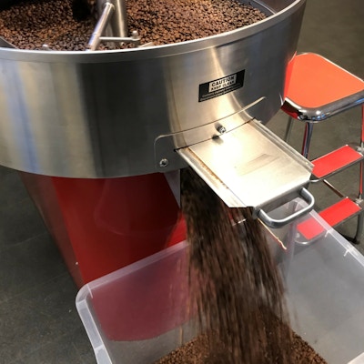 Kaffemaskin som maler kaffebønner ut i en beholder