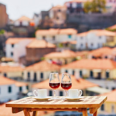 To glass Madeira-vin og to kopper fersk espressokaffe på kafé med utsikt til Funchal by, Madeira, Portugal