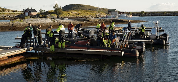 Flere personer i verneutstyr gjør seg klare til å sette av gårde i en RIB-båt på vannet