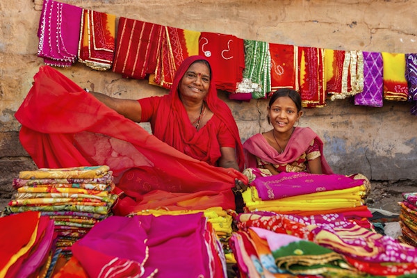 Mor og datter som selger fargerike tøystykker