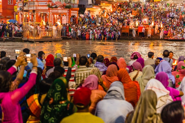 Tusenvis av hinduistiske pilegrimer / mennesker i den hellige byen Haridwar i Uttarakhand, India under kveldsseremonien kalt Ganga arthi for å tilbe elven Ganga / Ganges. Kultur, tradisjon, seremoni