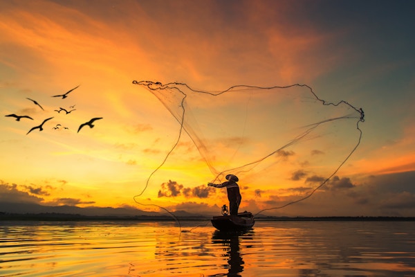 Fisker som fisker ved innsjøen i morgen, Thailand.