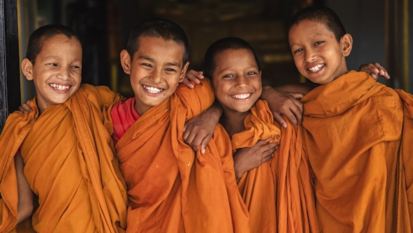 Gruppe av glade nybegynner-buddhistiske munker i dører i klosteret i Bhaktapur, Nepal. Bhaktapur er en gammel by i Kathmandu-dalen og er oppført som et verdensarvsted av UNESCO for sin rike kultur, templer og kunstverk av tre, metall og stein.