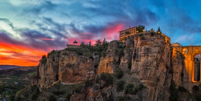 Lav vinkelsikt av bygninger på klipper ved byen Ronda under en solnedgang, Malaga-provinsen, Andalusia, Spain