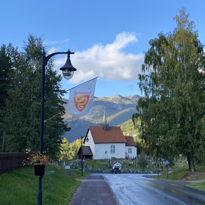 Vei fører til en kirke med et flagg som viser Seljord i forkant