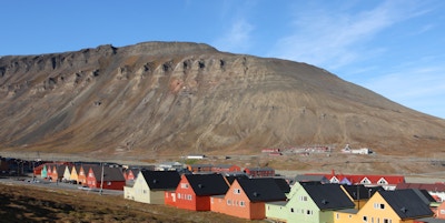Hus i rekker i ulike pastellfarger som har fjellet i bakgrunnen