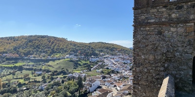 Utsikt fra en høyde over en spansk by, en del av et tårn synes såvidt i bildet