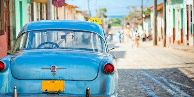 Drosjebil i en trang gate i Trinidad, Cuba