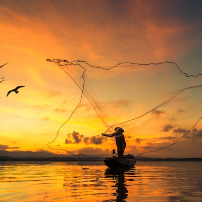 Fisker som fisker ved innsjøen i morgen, Thailand.