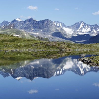 Refleksjon av fjellkjede i et lite hav i Jotunheimen nasjonalpark i Norge.
