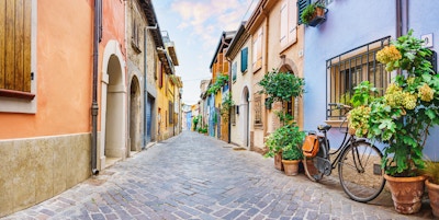 Smal gate i landsbyen til fiskerne San Guiliano med fargerike hus og en sykkel tidlig om morgenen i Rimini, Italia