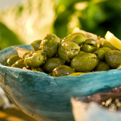 En turkis skål full av grønne oliven