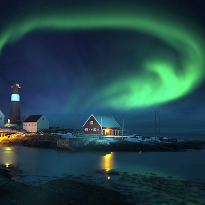 Spektakulær form på nordlys (Aurora borealis) over fyrtårn ved sjøen om vinteren.