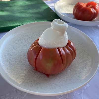 Rød tomat med en dæsj hvit mozzarella på toppem