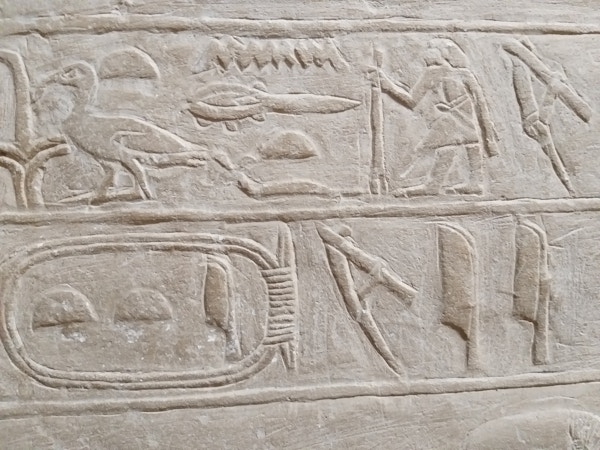 Hieroglyfer som nærbilde risset inn på en vegg