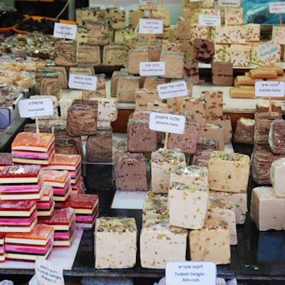 Israel, Tel Aviv, Carmel markedet, mai 2017, forskjellige typer tradisjonelle søtsaker: syltetøy og halva på en markedsbod